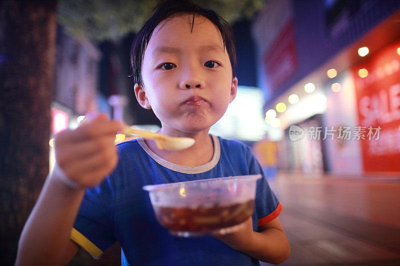 亚洲小孩用筷子吃美味的面条