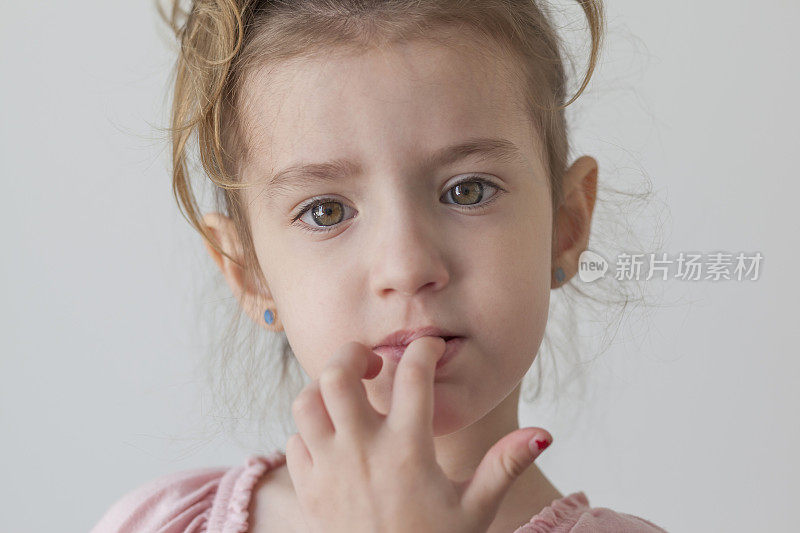 小女孩看着镜头咬着指甲