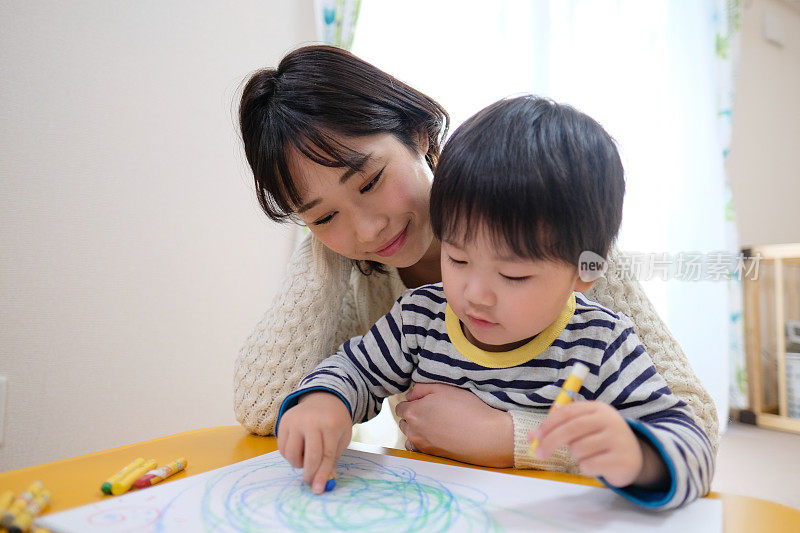 孩子和妈妈在家里画画