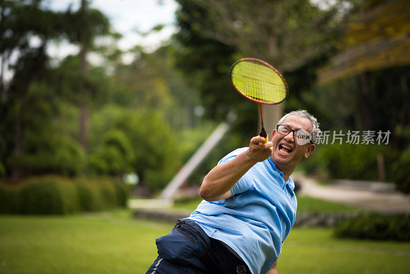 一个老人在公园里打羽毛球