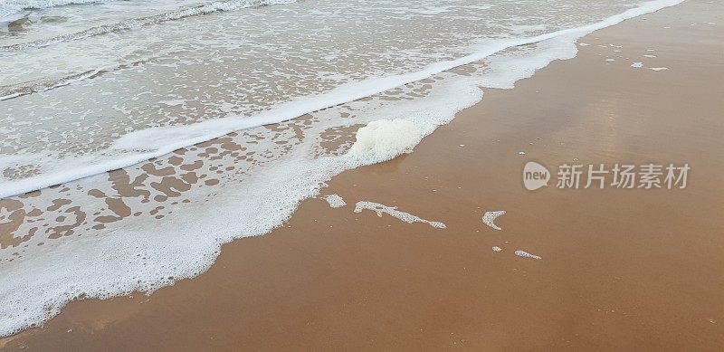 泡沫状的白色海浪拍打着海滩