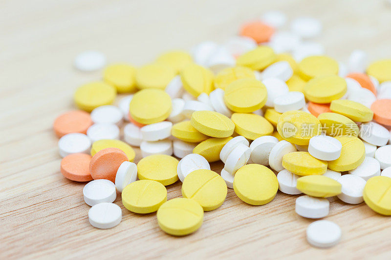 彩色药片剂或药片近距离放在木桌背景上。