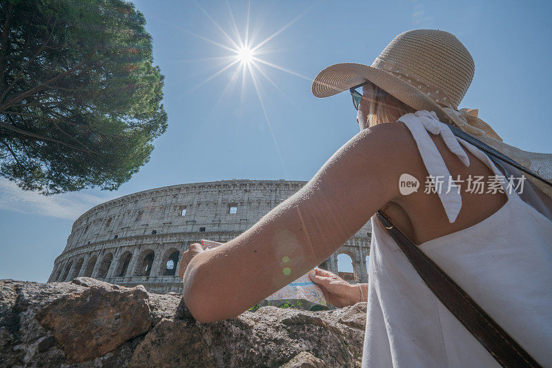 年轻女子在罗马斗兽场看旅游地图问路;人们旅游欧洲首都城市的概念