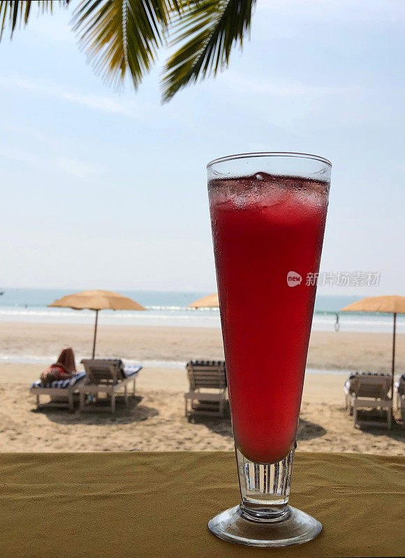 印度果阿，海滩上的性感图片，热带棕榈树下的鸡尾酒，海边度假胜地的阳光躺椅