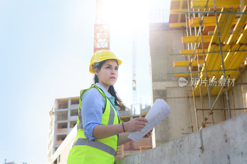 女建筑师在一个建筑工地认真地看着蓝图