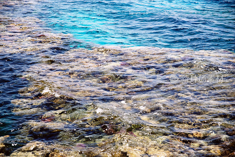 蓝色的海水和白色的阳光反射，波纹的水面背景