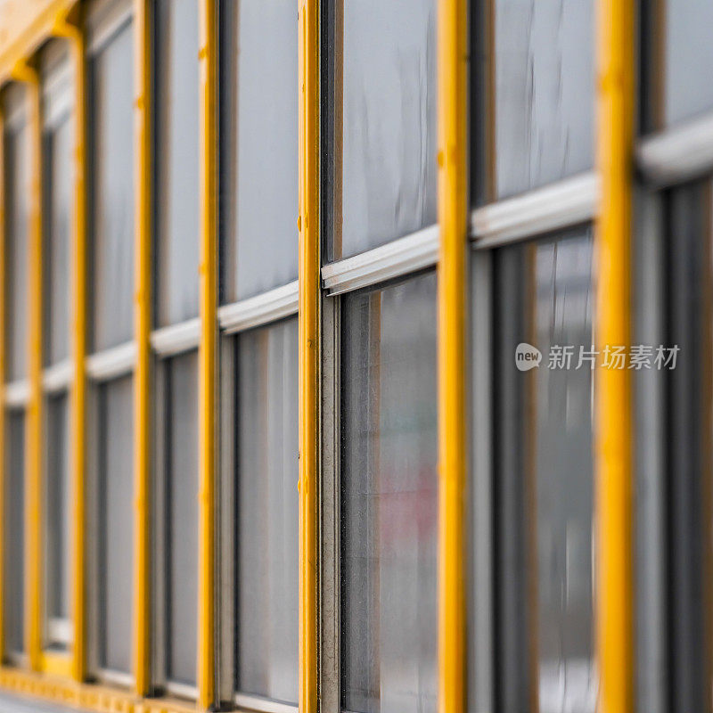 一辆黄色校车的方形外景，靠近玻璃窗