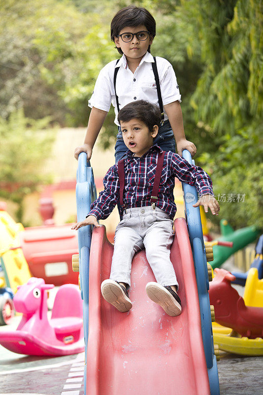 小男孩在游乐场滑滑梯