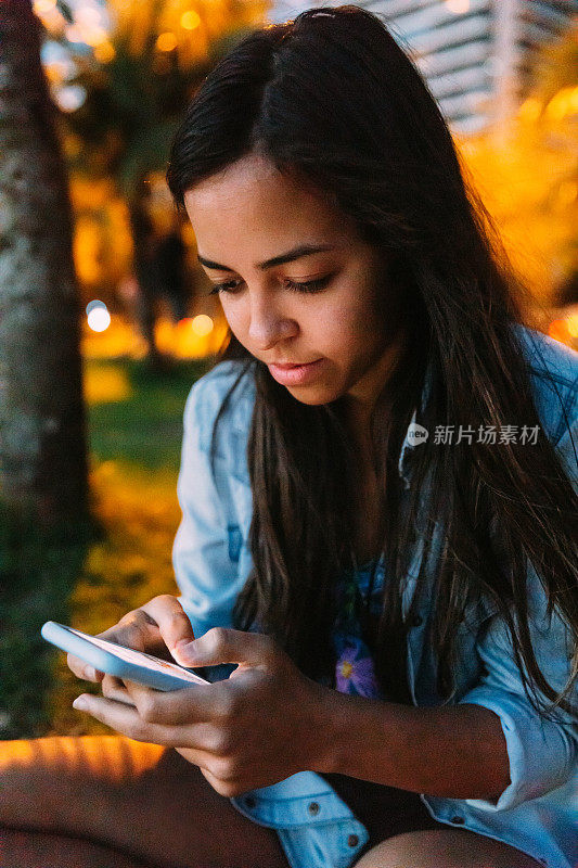 一名年轻的巴西女子在户外使用智能手机