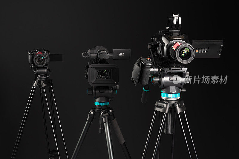 三种不同类型的视频电影摄影相机上的黑色背景，正面视图