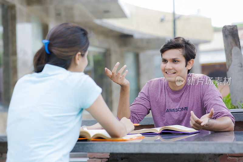 开朗的少女与同学在大学学习库存照片