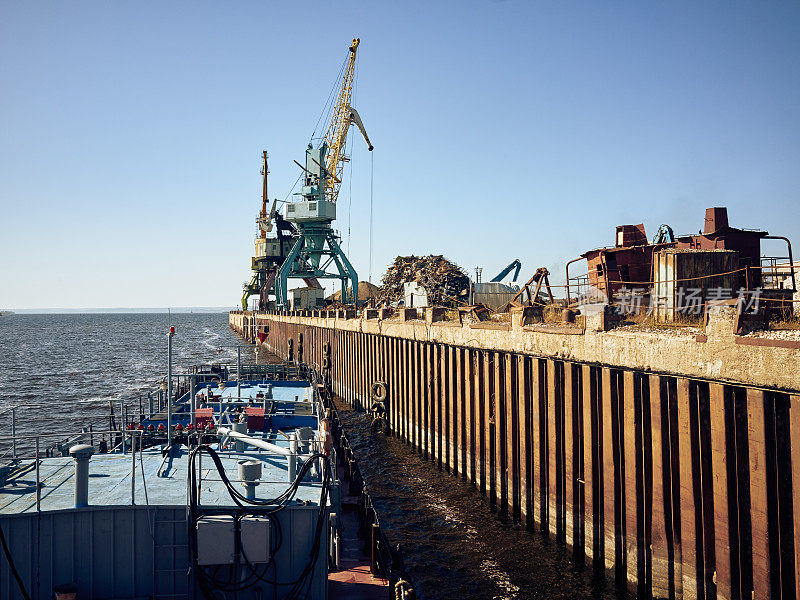 金属码头和重型起重机在港口卸货驳船