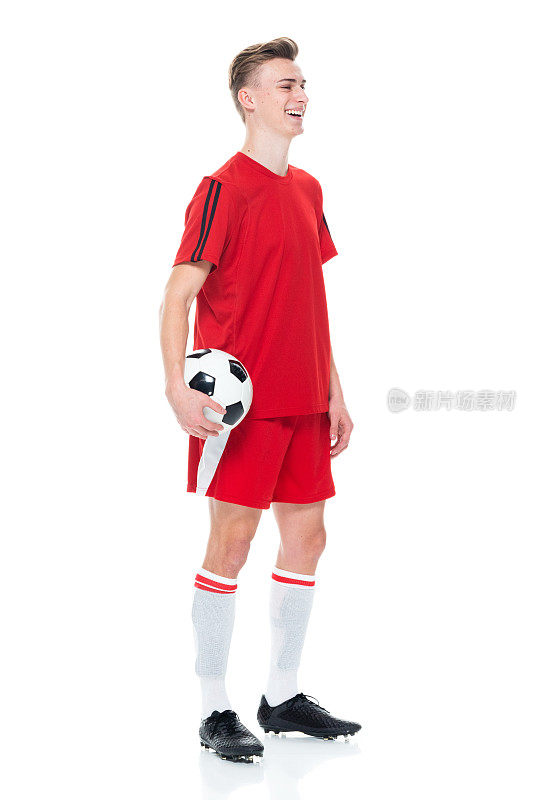 白人男性运动员穿着足球制服站着，手持足球，进行足球运动和使用运动球