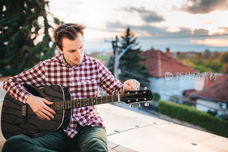 一个年轻人在阳台上弹吉他