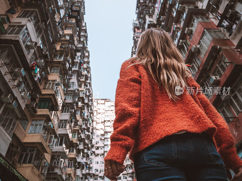 香港，一名女子抬头看着拥挤的公寓