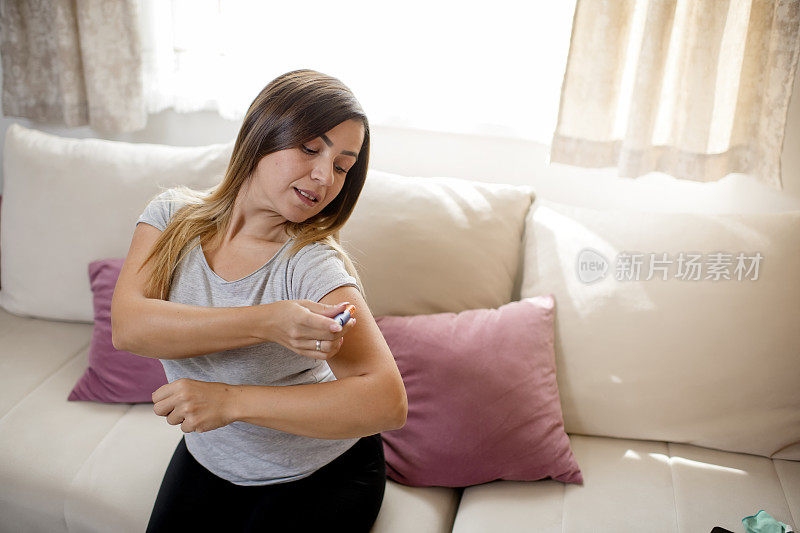 年轻女子在手臂上注射胰岛素