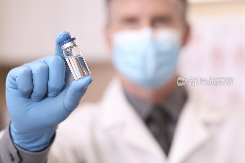 COVID-19:医生准备接种疫苗。近距离的手，小瓶。
