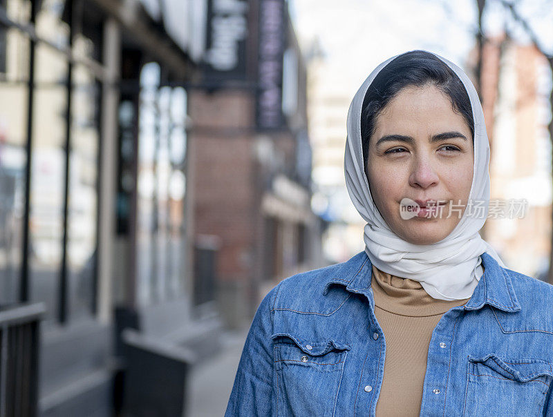 年轻的穆斯林成年女性戴着头巾站在户外