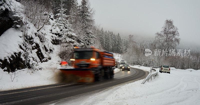 一辆清理车辆正在清理哈尔茨山脉上刚下过雪的道路，一排汽车跟在铲雪车后面