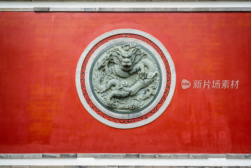 中国云南大理古城大理文庙的红墙，上面有龙的圆形雕塑