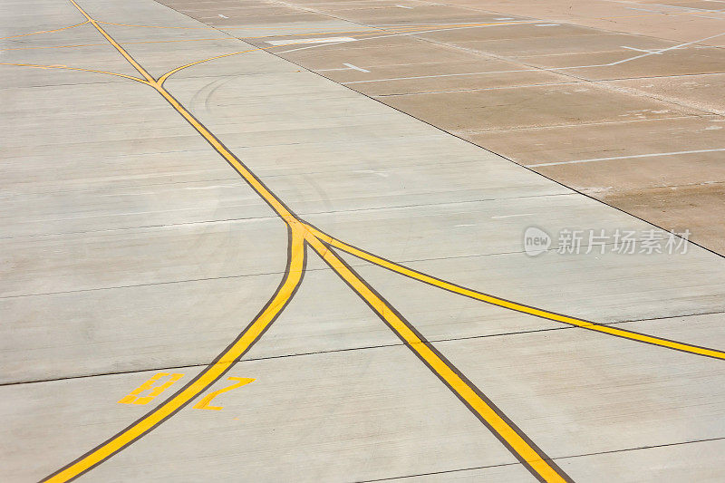 机场跑道上的黄色滑行道标记在混凝土沥青上，是飞机驾驶员的标志。