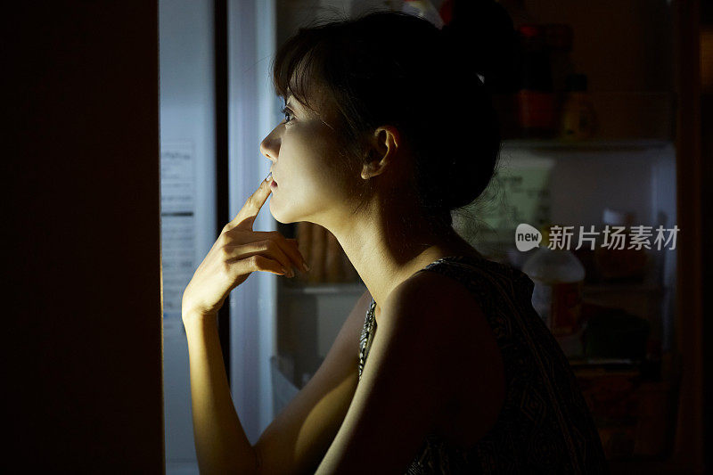 年轻的亚洲女人在深夜吃东西