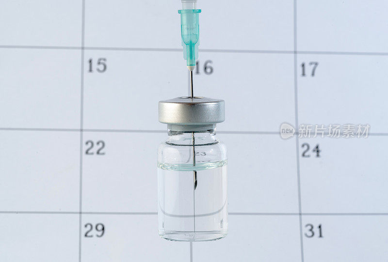注射器和疫苗的日历库存照片