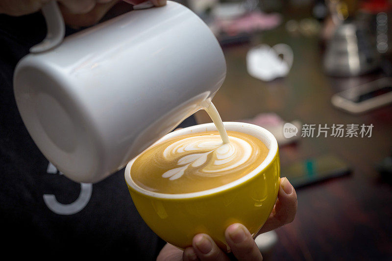 咖啡师在咖啡店用咖啡机制作咖啡拉花