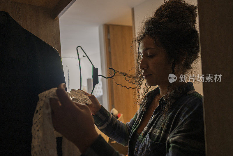 一位妇女在她新家的壁橱里整理她的衣服