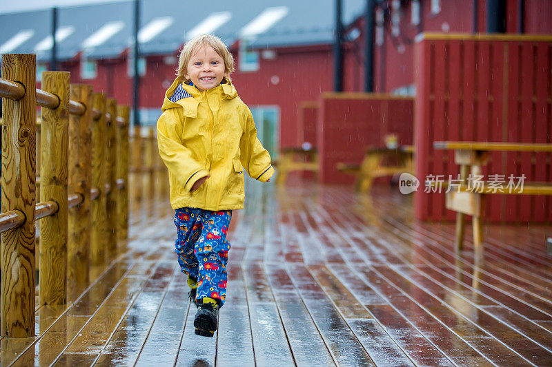 可爱的孩子，在一个大雨天享受着小渔村和罗布尔小屋