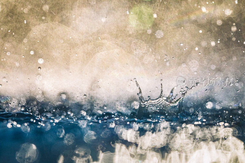 在金色的灯光下，雨落在蓝色的水面上