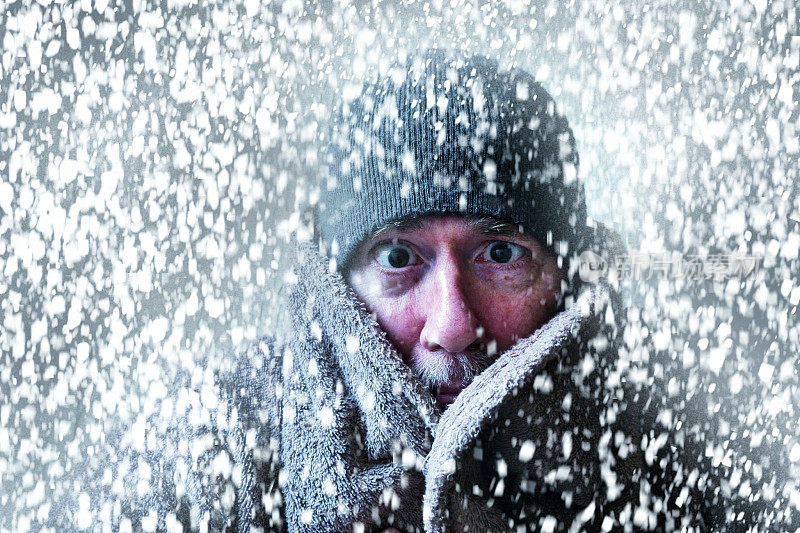 一个男人在暴风雪中瑟瑟发抖的冬季场景