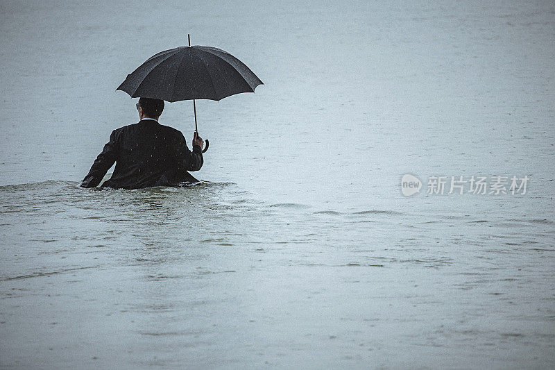 帅男撑着伞在雨中走过