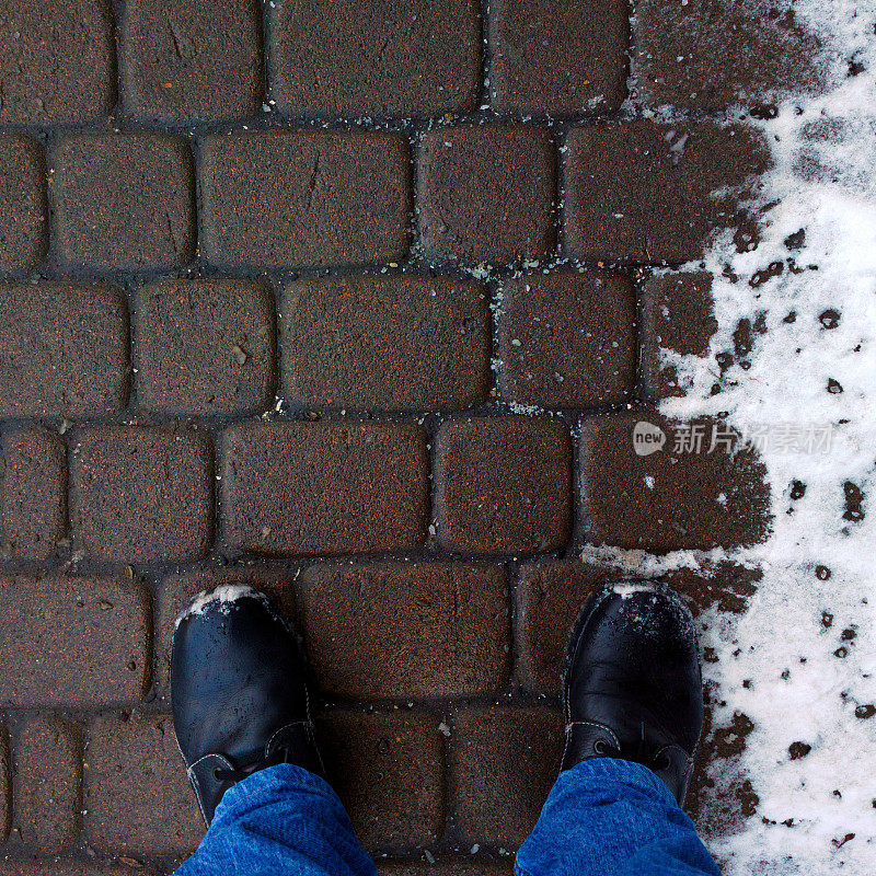脚踩在铺着雪的鹅卵石上。