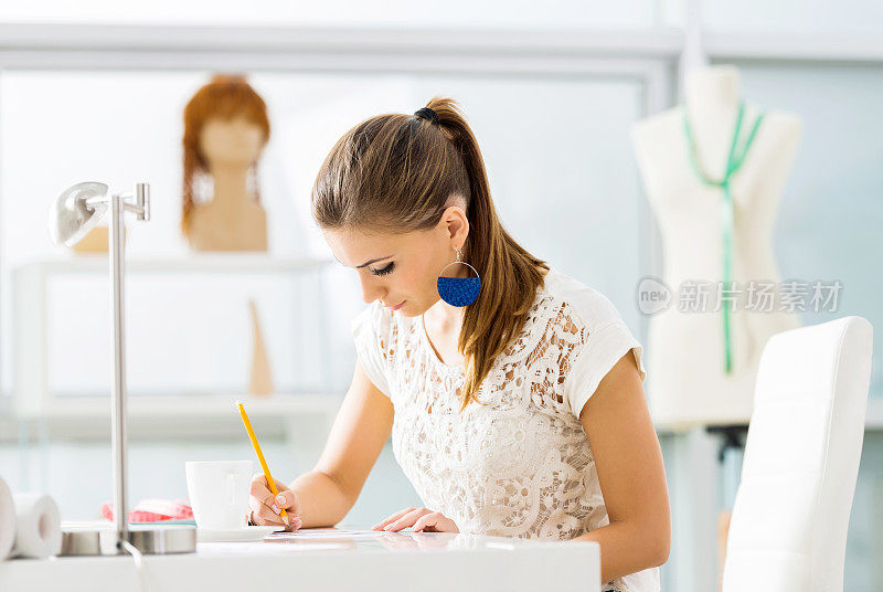 时装设计师在她的工作室素描。