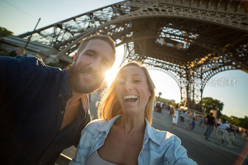 一对兴高采烈的年轻夫妇在巴黎埃菲尔铁塔自拍