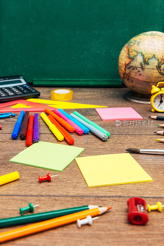 学校物品，铅笔，计算器和地球仪在空木板上