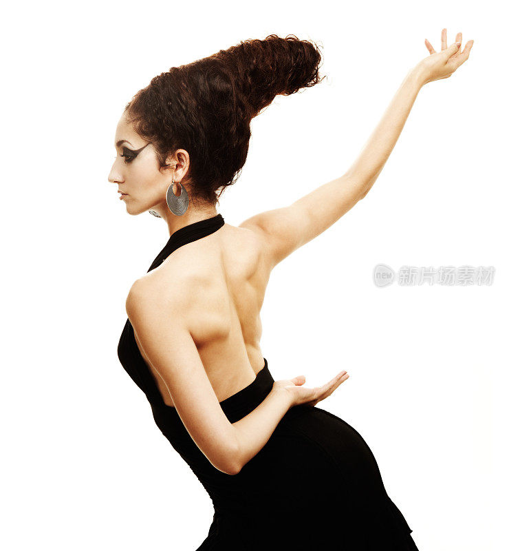 美丽的女性黑发舞者在戏剧性的姿势与背部暴露