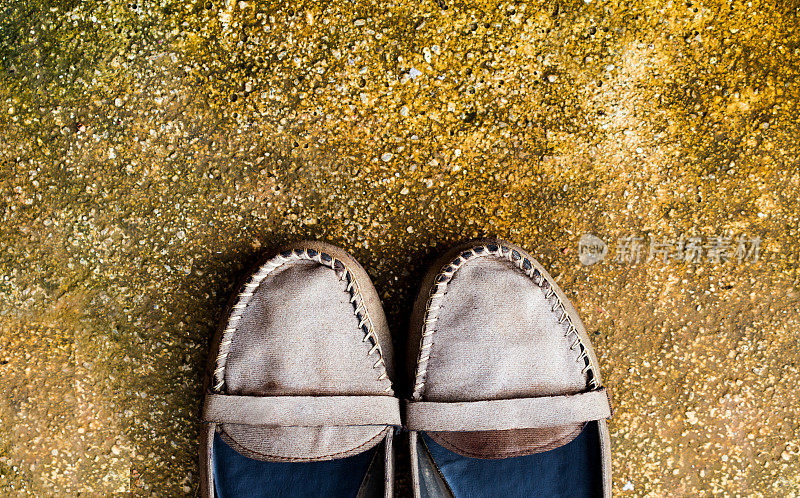 水泥背景上的旧鞋