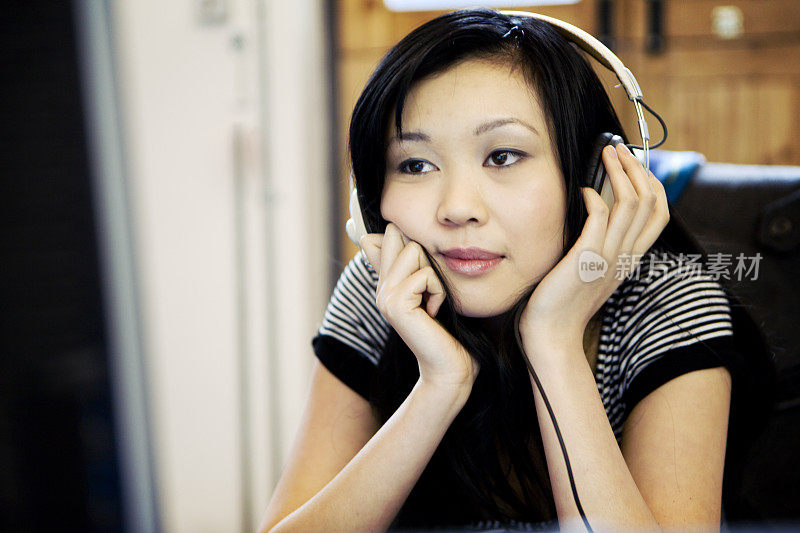 现代工作场所:亚洲女孩放松与一些轻松的倾听