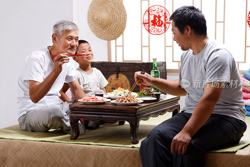 农民祖孙三代坐在家中吃饭