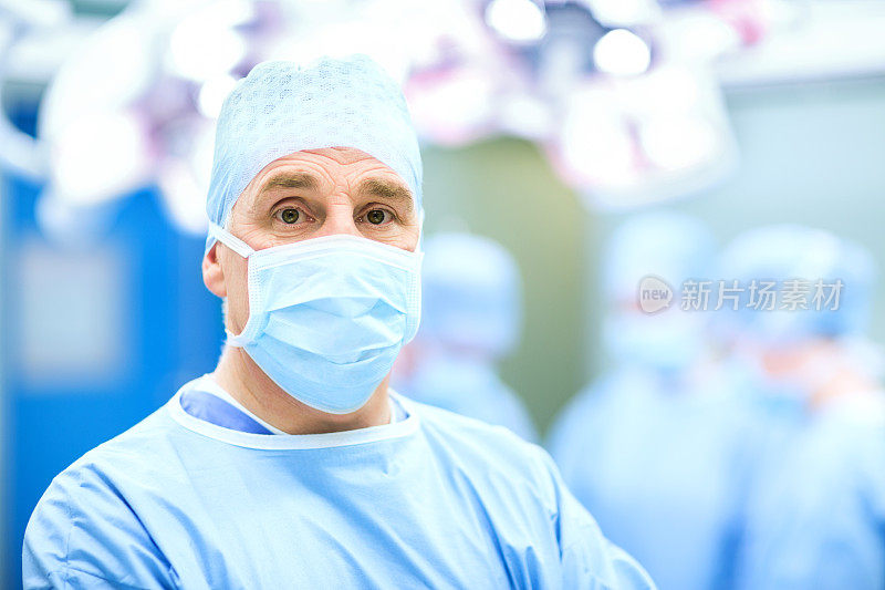 在手术室戴医用口罩和手术帽的男性外科医生