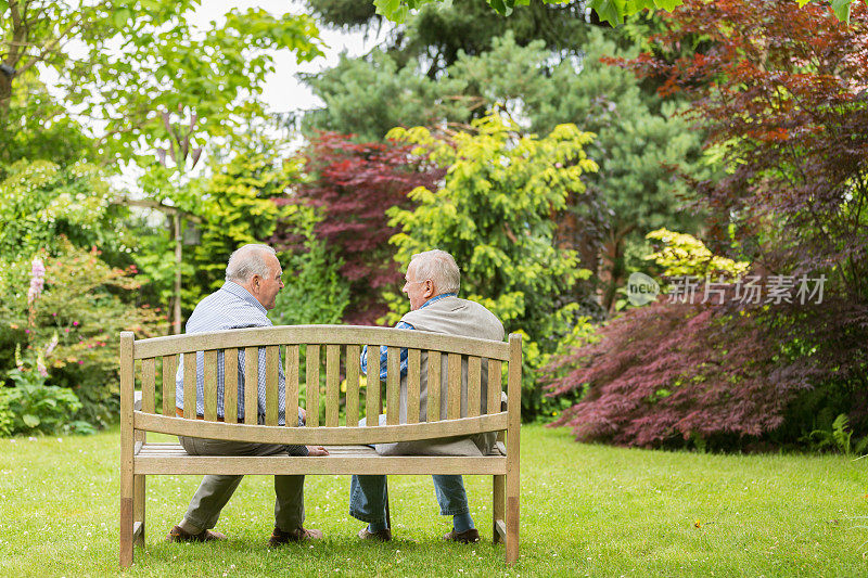 两个老人坐在公园的长椅上