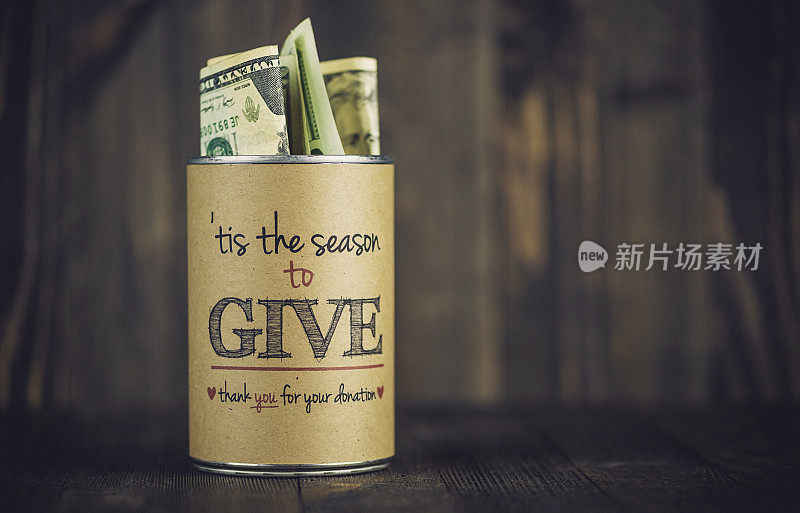 慈善募捐罐头对木制背景。美国假日筹款