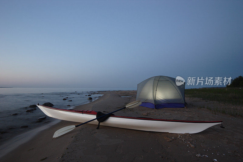 晚上海滩上的皮艇和照明帐篷