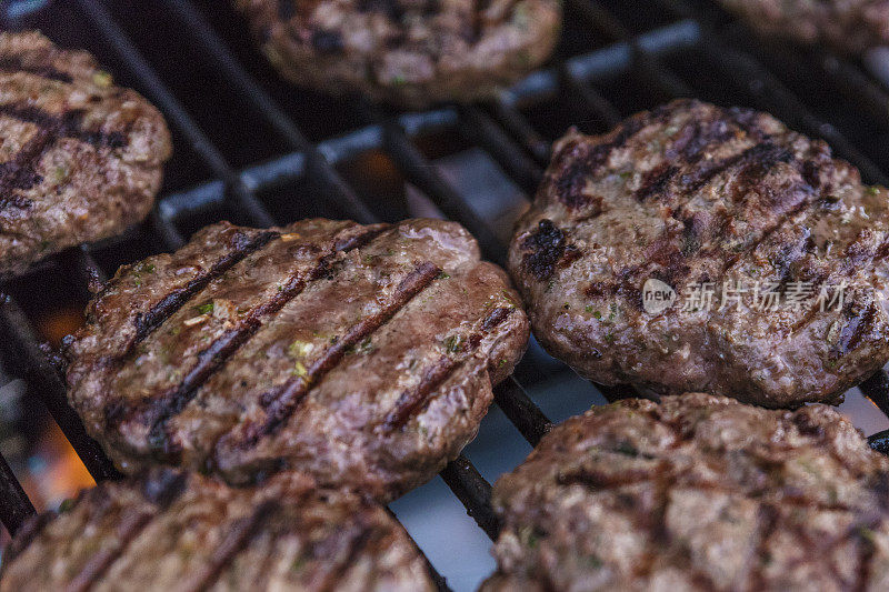 特写牛肉饼在木炭上烹饪汉堡包。