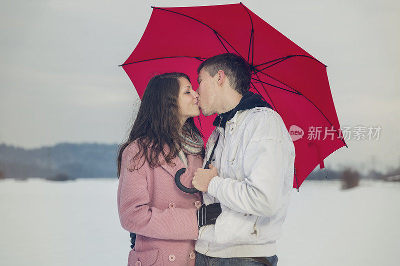 一对幸福的年轻情侣在雪地上接吻