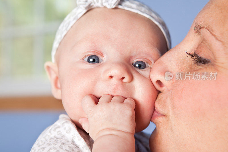 母亲亲吻女婴的脸颊
