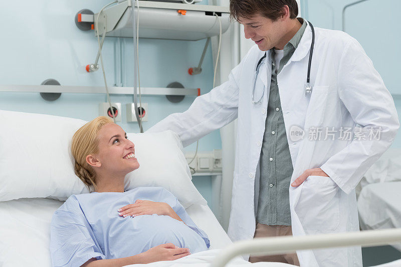 怀孕的病人躺在床上，她的医生正在说话