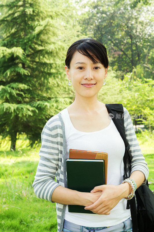 在校园内持书的亚洲女学生